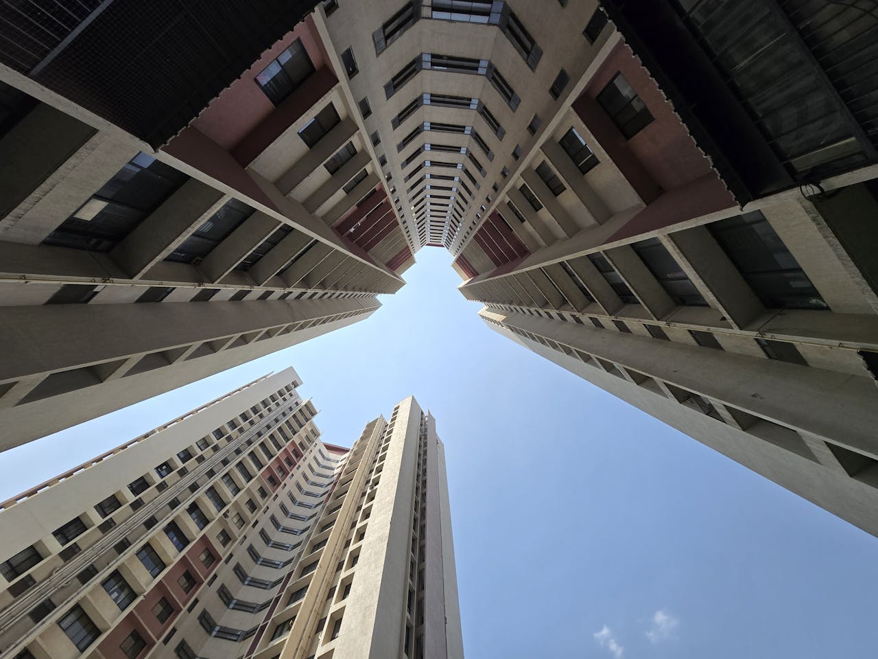 about-01 Dramatic upward view of modern skyscrapers against a clear blue sky in Pune, India.